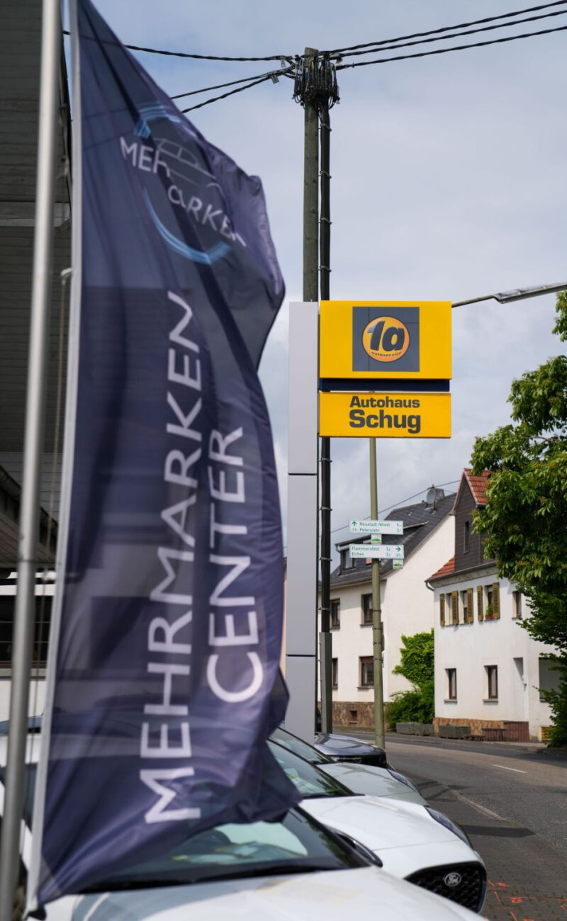 autohaus-schug-start Eingang Autohaus Schug mit Flagge