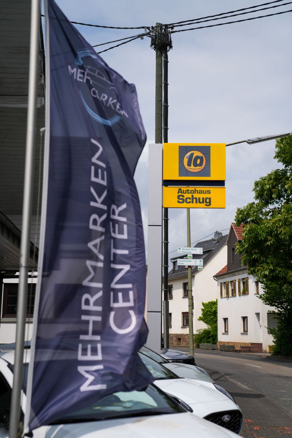 autohaus-schug-start Eingang Autohaus Schug mit Flagge